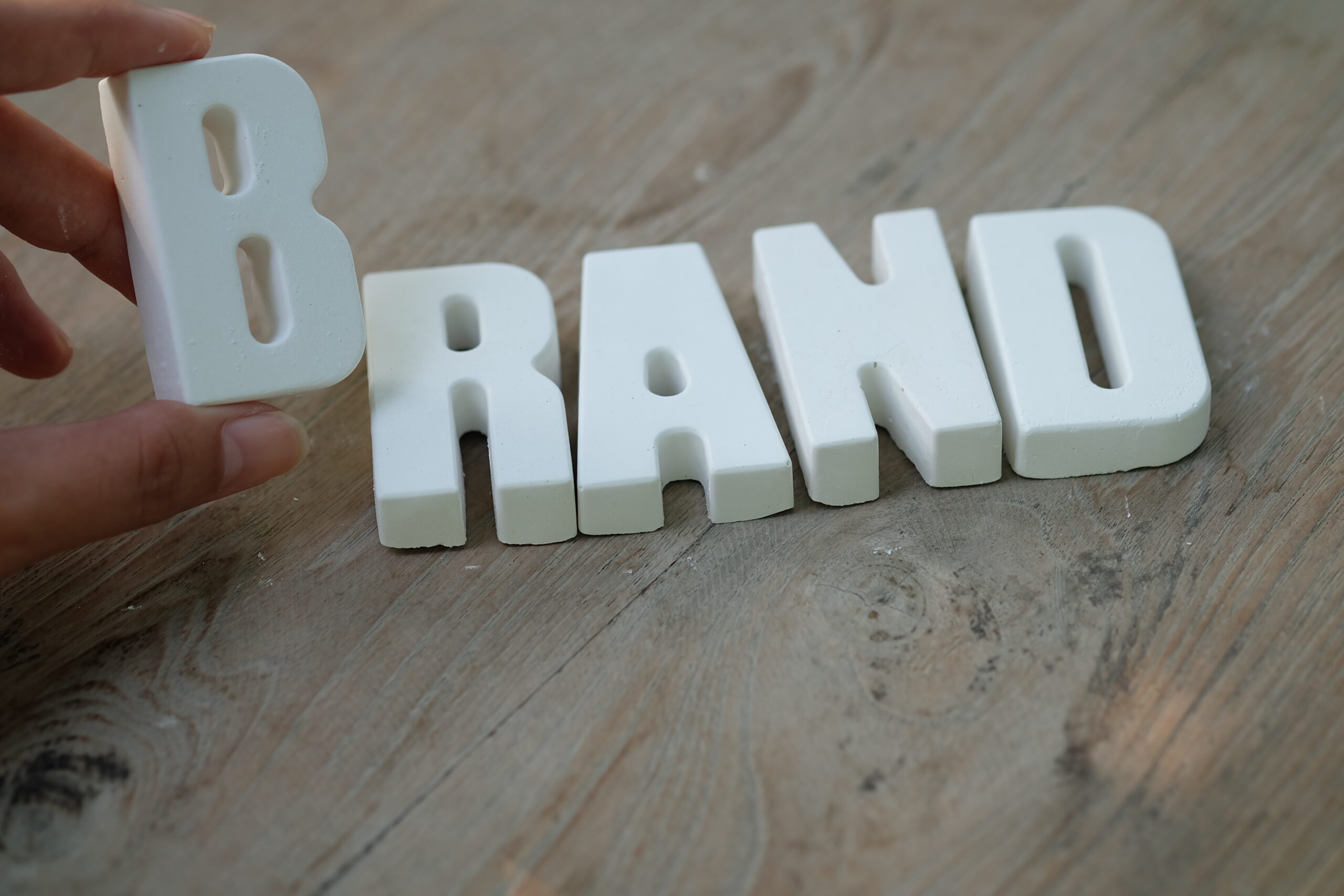 hand arrange white letters brand scaled