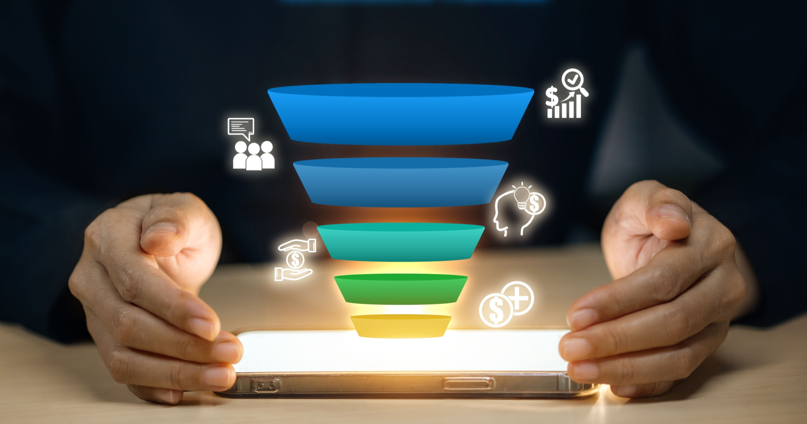 Hands holding a glowing smartphone displaying a colorful digital marketing sales funnel graphic with icons for audience, ideas, and revenue growth.